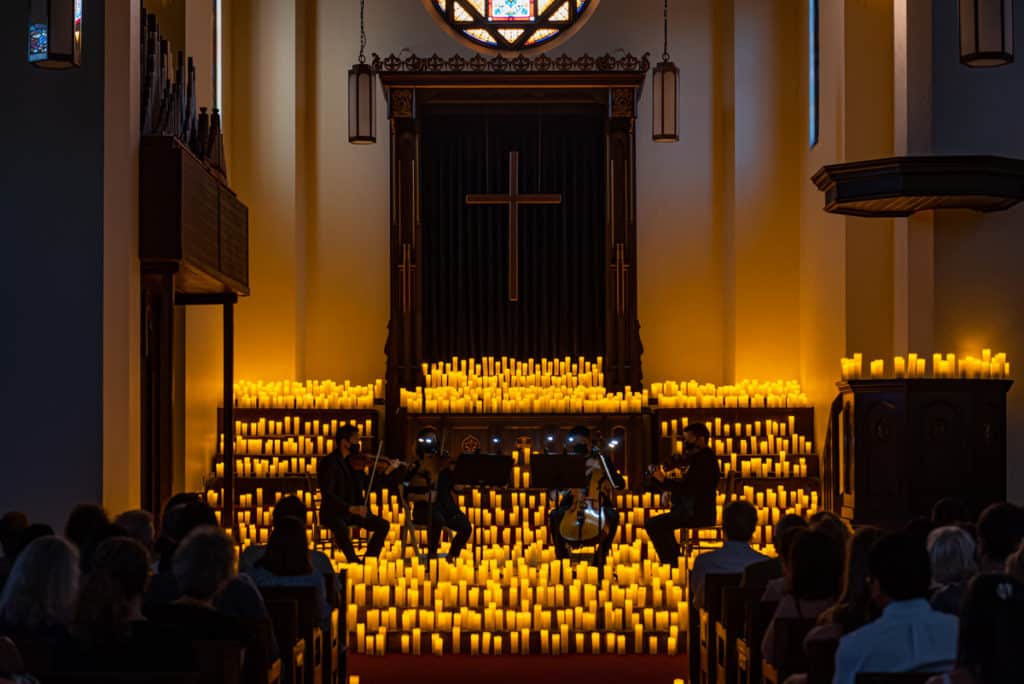 A string quartet plays by candlelight